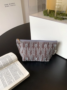 Detail of embroidered rabbit pattern on cotton linen makeup bag with premium metal zipper