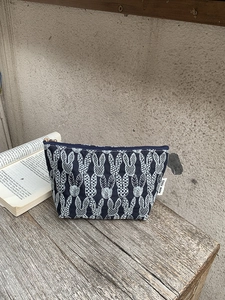 Detail of embroidered rabbit pattern on canvas makeup bag with Little Moon label