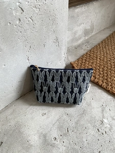 Detailed embroidery of white rabbits on deep blue cotton linen fabric of this storage bag
