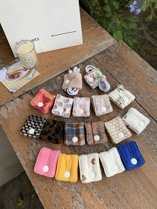 Close-up of fabric cable organizers in various patterns on a vintage wooden table