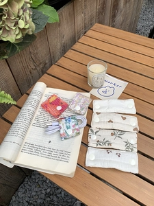 Quilted fabric cable organizers with floral patterns and snaps on a wooden table