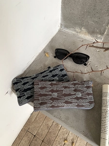 Detail of embroidered linen glasses pouch with rabbit pattern and metal zipper closure