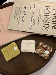 Detailed view of fabric cable organizers in corduroy, quilted, and plaid textures