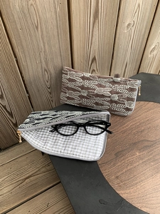 Detailed view of linen eyewear pouches with leaf embroidery and checkered cotton lining