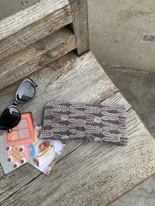 Detailed shot of embroidery linen glasses pouch with rabbit pattern on a wooden surface