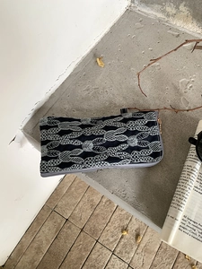 Embroidered linen glasses pouch with rabbit and leaf pattern on cement steps