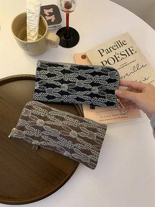 Close-up of embroidered cotton linen glasses case with leaf pattern and golden zipper puller