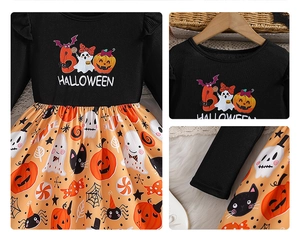 Detail of girls Halloween dress featuring orange pumpkin patterns and embroidered bodice