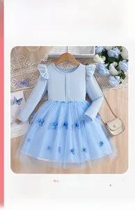 Detail eines blauen Mädchenkleides aus Tüll mit Schmetterlings-Applikationen und Strick