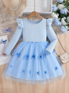 Hellblaues Langarmkleid für Mädchen mit Strickoberteil und Schmetterlings-Tüllrock auf Holz