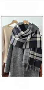 Detailed close-up of warm winter scarf with black, white and grey plaid and long fringes
