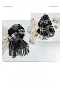 Detailed view of the soft plaid cashmere-feel scarf with elegant fringe trim and soft texture