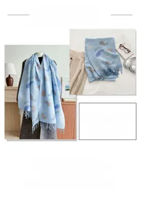 Detail of light blue paisley scarf with tassels showing soft knit texture and fringe edge