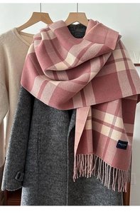 Detail of pink and white plaid scarf featuring soft fringe and blue woven brand label
