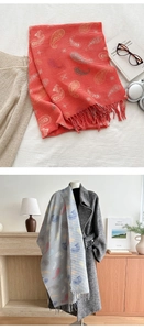 Detail of coral and grey paisley pashmina scarf with fringe and soft knit texture
