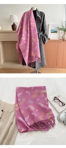 Close-up of pink paisley knit scarf with premium tassel fringe and soft striped texture