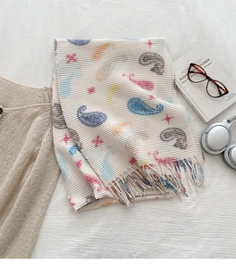 Detail of white paisley scarf featuring colorful tassels and soft pleated texture