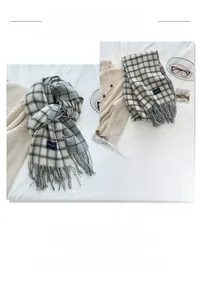Detail of grey and beige plaid scarf showing fringe edges and soft woven texture