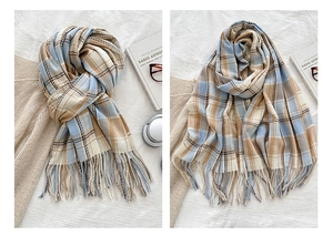 Detailed view of light blue plaid scarf with soft fringe and elegant cashmere texture