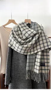 Detail of soft plaid scarf with fringe tassels draped over a winter coat