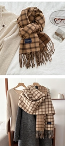 Detailed view of brown plaid scarf fringe and elegant brand label on cashmere texture