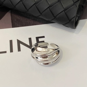 Detailed view of fluid wave texture and polished finish on the adjustable silver ring