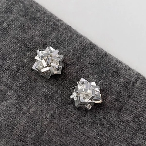 Minimalist irregular geometric silver earrings with stacked cube design on knit fabric