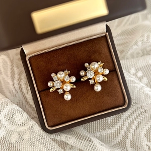 Detail shot of elegant gold pearl cluster earrings with sparkling cubic zirconia stones