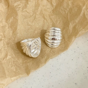 Gros plan de boucles d'oreilles argentées vintage au design texturé plissé