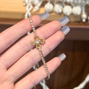 Macro detail of gold flower bracelet with sparkling cubic zirconia on female hand