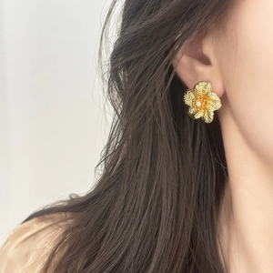 Elegant gold flower stud earrings with zircon center on model for a vintage chic look