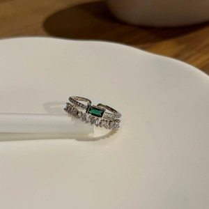 Detailed macro view of a double-layered emerald green ring with step-cut zirconia accents