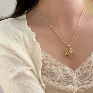 Elegant gold necklace with radial sunburst pendant on a refined twisted rope chain