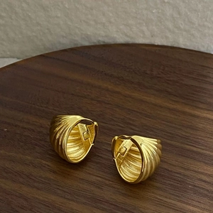 French vintage gold ribbed hoop earrings with a textured finish on dark wood