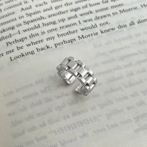 Macro shot of silver link chain open ring placed on a book page with industrial style