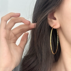 Chic gold-plated geometric hoop earrings with handcrafted hammered texture on a model