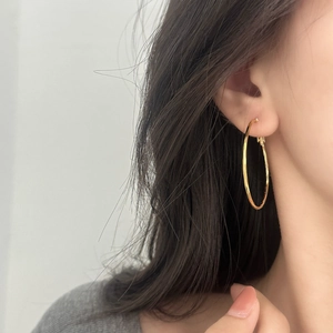 Minimalist large gold hoop earrings for women, stylish geometric metal jewelry worn by model