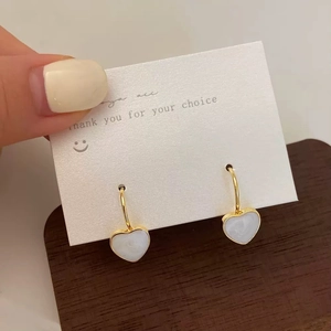 Boucles d'oreilles cœur dorées avec texture marbre blanc sur carte de présentation