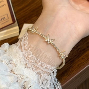 Elegant gold butterfly bracelet with sparkling zircon stones worn on a lace sleeve