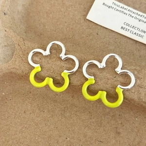 Detail of sweet floral earrings featuring silver finish and neon yellow enamel accents