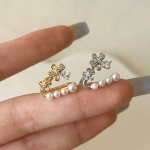 Clips d'oreilles fleurs élégants avec zircons brillants et perles en finition or et argent