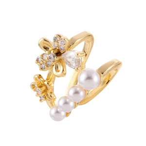 Manchette d'oreille dorée avec fleurs en zircon et perles blanches sur fond blanc