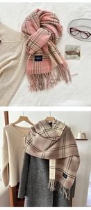 Dettaglio di sciarpe a quadretti con nappe in rosa e marrone con trama morbida e moda