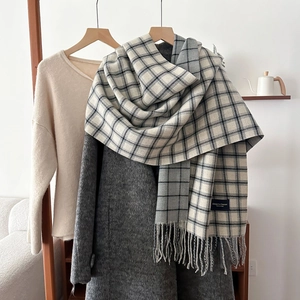 Plaid tassel scarf in grey and beige tones on grey coat, elegant winter neckwear