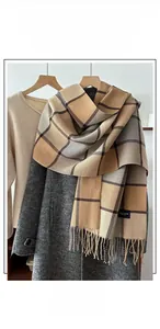 Close-up of winter plaid scarf with long tassels and thick khaki color block texture