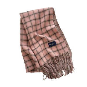 Pink and brown plaid scarf with tassels featuring Elegant and Classic label in flat lay