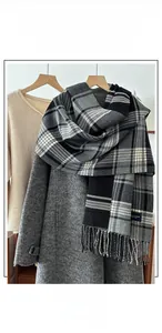 Detailed view of striped plaid scarf featuring fringe edges and soft cashmere-like texture