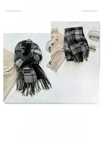 Detailed view of soft cashmere-like scarf featuring classic plaid patterns and tassel fringe