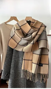 Close-up of classic khaki plaid winter scarf with tassels and elegant brand label