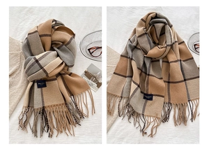 Detail of winter checkered scarf with fringes and cozy soft fabric texture